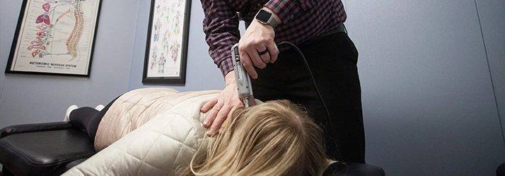 Chiropractor Anchorage AK Kelly Ryan Adjusting Patients Neck With Tool